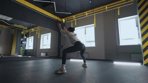 Sporty Woman Doing TRX Exercises in the Gym