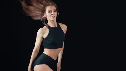 Sexy Tänzerin mit perfektem Körper und langen Haaren posiert