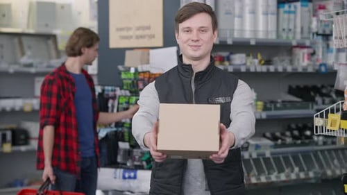 Man Holding Box in Retail Store Environment