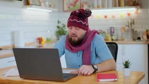Man With Cold Working from Home on Laptop