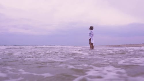 Girl Walks on the Beach on the Background of the Sea