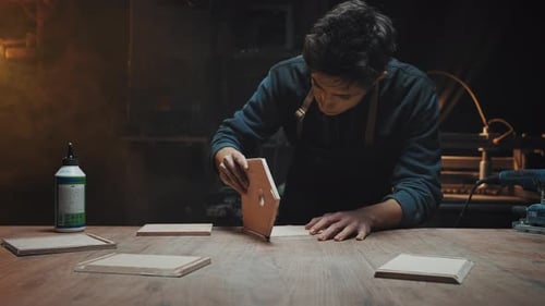 Young Adult Gluing Wood in a Workshop