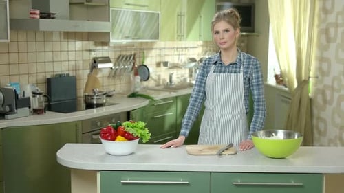 Woman in Kitchen Stands near Fresh Vegetables