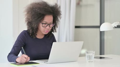 Woman Works On Laptop With Stylus and Tablet