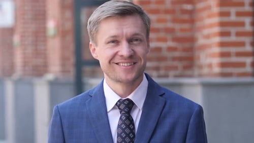 Man Smiling in Blue Suit in Urban Setting