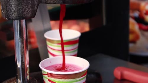 Juice Pouring into Cup from Metal Juicer