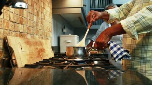 Adult Stirring Pot on Stove in Kitchen