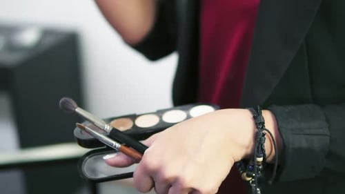 Focus Moving From Box with Eyeshadows of Different Colours to the Closeup View of Makeup Artist