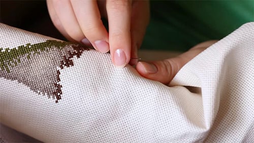 Close Up of Hands Sewing Canvas with Needle