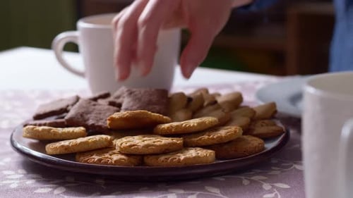 Hand Picking a Cookie From Assorted Plate