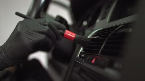 Gloved Hand Cleaning Car Interior Vent