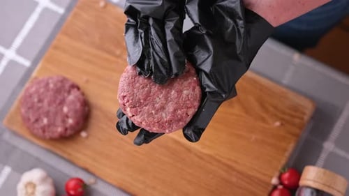 Woman Chef in Black Gloves Prepares Cutlets at Domestic Kitchen on a Wooden Cutting Board