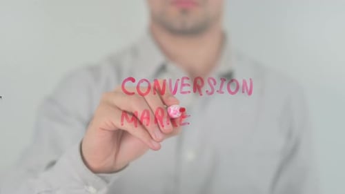 Man Writes Conversion Marketing on Clear Surface