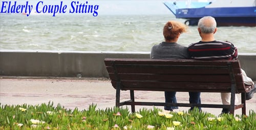 Elderly Couple Relaxing on Bench Overlooking Ocean