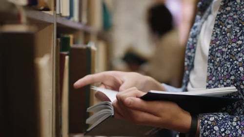 Junger Mann liest ein Buch, Nahaufnahme der Hände