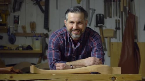 Adult Man Presenting Wooden Craft in Workshop
