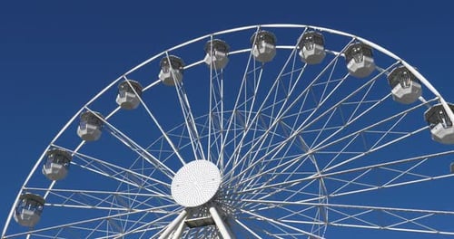 Une grande roue en action sur fond de ciel bleu.