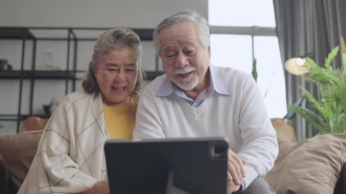 Senior Couple Video Calling from Couch in Living Room