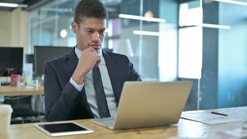 Young Adult Working On Laptop in Modern Office