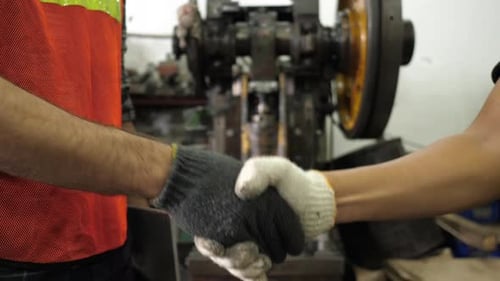 Men Shaking Hands in Industrial Workplace