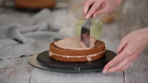 Icing a Chocolate Cake at Home in Daylight