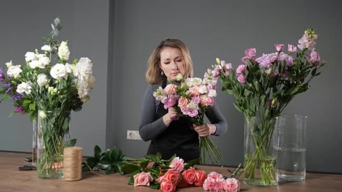 Une fleuriste compose un bouquet élégant avec des fleurs colorées