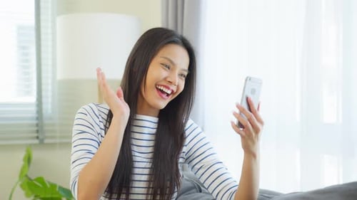 Smiling Woman Video Calling on Smartphone at Home