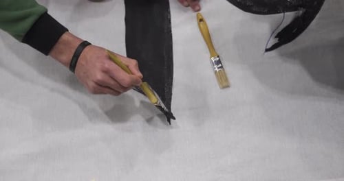 Hand Painting Black on a Surface with Brush