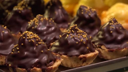 Nahaufnahme von Obst- und Schokoladen-Cupcakes auf metallischen Tabletts