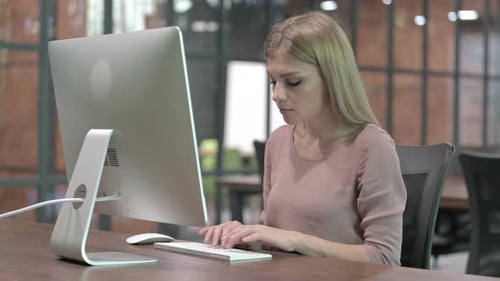 Young Woman Working at Computer in Office