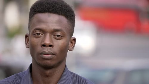Proud handsome black african young man looking at camera in the street