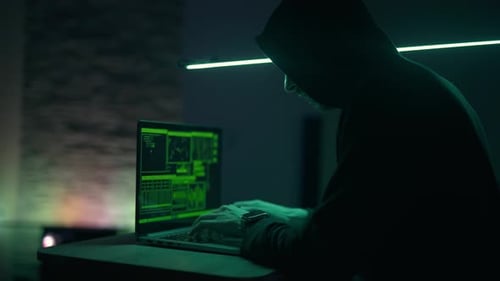 Hacker está trabalhando em laptop à noite