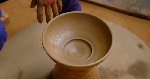 Des mains habiles de potier façonnent l'argile sur Potter Wheel et sculptent un pot en argile. Shipagramme
