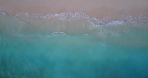Wide birds eye travel shot of a sunshine white sandy paradise beach and aqua blue ocean background