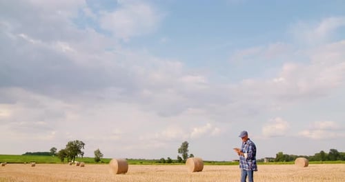 Farmer Using Digital Tablet While Examining Field