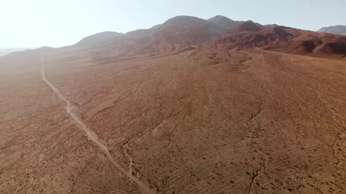 Aerial shots of the barren, sandy, rocky, mountain filled, Mojave Desert on a sunny day.