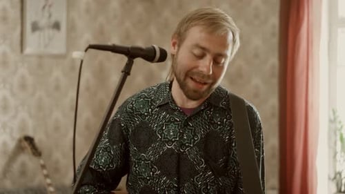 Bearded Man Singing and Playing Acoustic Guitar
