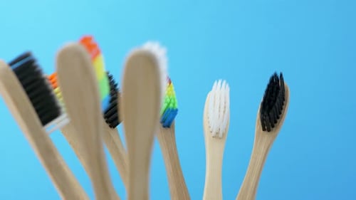 Bamboo Toothbrushes with Colorful Bristles on Blue Background