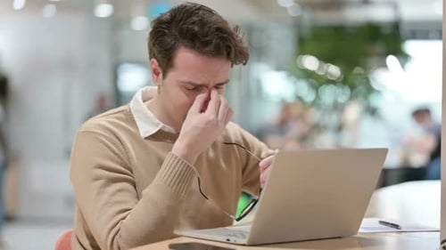 Young Adult Typing on Laptop at Office Desk