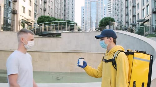 Contactless Delivery Man Giving Coffee in Urban Setting