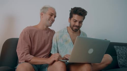 Men Using Laptop Computer Together on Couch