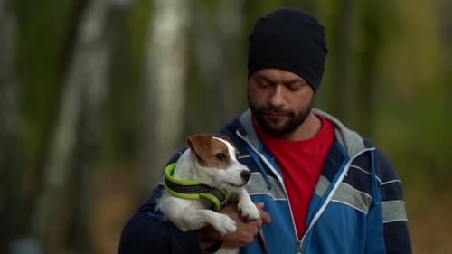 Walk of Dog Owner and Jack Russell Puppy in Autumn Forest, Man Is Holding Animal on Hands and