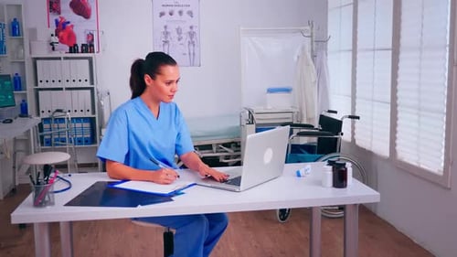 Female Doctor Working at Desk in Doctor's Office