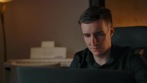 Young Man Working Late at Laptop Computer