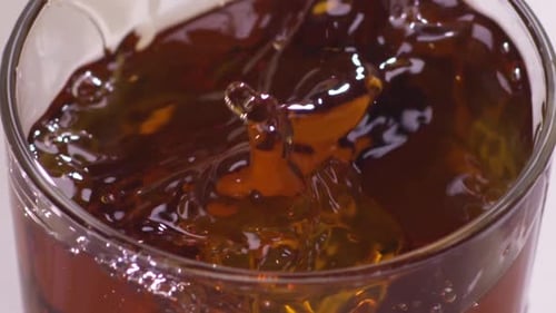 Whisky Splash isoliert auf weißem Hintergrund. Zeitlupe. Nahaufnahme