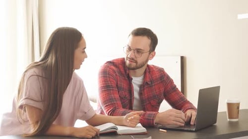 Couple Collaborating on Laptop at Home Desk