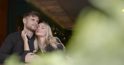 Romantic Young Couple Hugging and Sitting in a Cafe