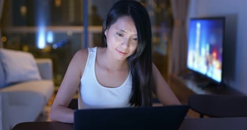 Woman Works on Laptop at Night in Apartment