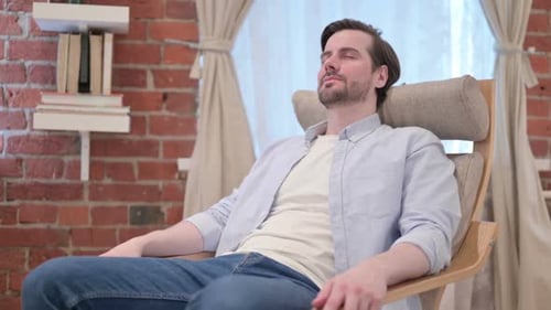 Young Man Taking Nap While Sitting on Sofa