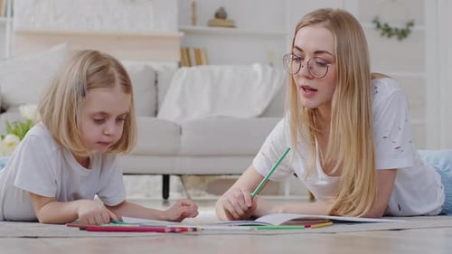 Blonde Child and Adult Drawing Together at Home